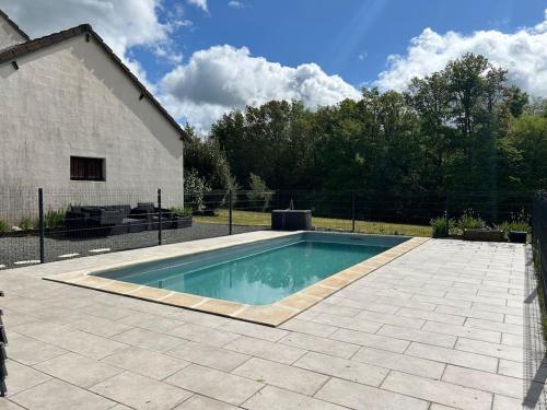 - une piscine dans une cour à côté d'un bâtiment dans l'établissement Maison avec piscine classée 3 étoiles, à Sainte-Trie