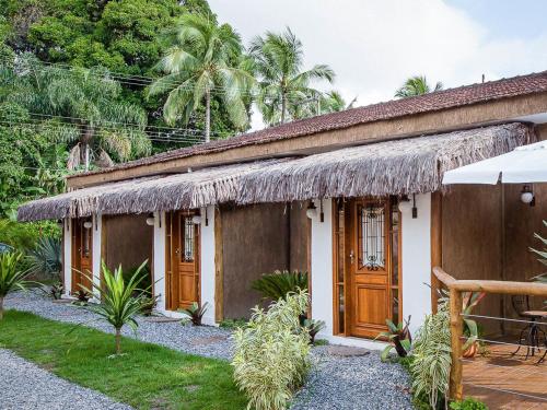 una casa con techo de paja en Pousada de Charme Emirados en Ilhabela