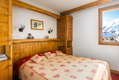 a bedroom with a bed and a window at travelski home select - Résidence L'Ecrin des Sybelles in La Toussuire