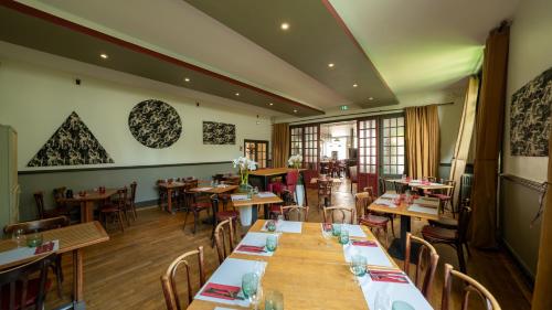 a restaurant with tables and chairs in a room at Le Relais Du Canalou in Digoin