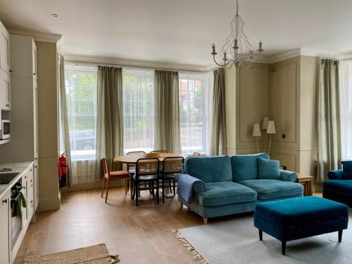a living room with a blue couch and a table at Garden Beach Apartment, Hunstanton Norfolk in Hunstanton