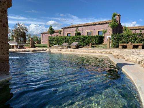 a pool of water in front of a building at Resort Fonte Vulci in Canino