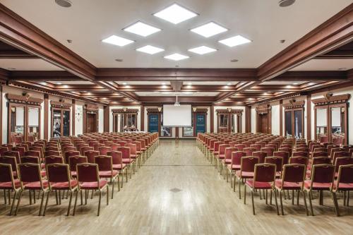 an empty room with chairs and a projection screen at Verdi Budapest Aquincum in Budapest