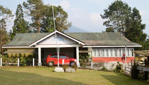 a red car parked in front of a house at Silk Route Resort Aritar in Rhenok