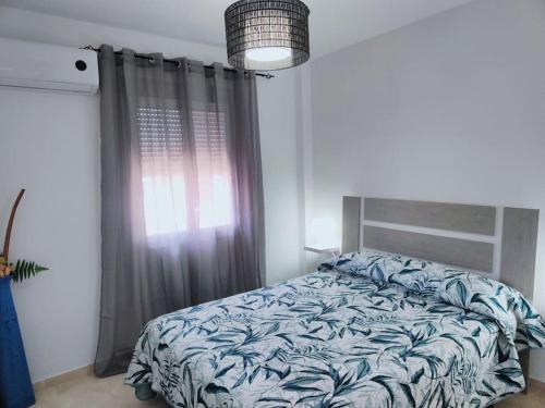 a bedroom with a bed in front of a window at Las Palmeras in Matalascañas