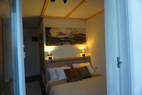 a bedroom with a bed with two lamps on the wall at Hill Homes Montenegro in Petrovac na Moru