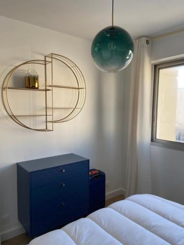 une chambre avec deux lits et une commode bleue et un miroir dans l'établissement Lily blue, à Vichy