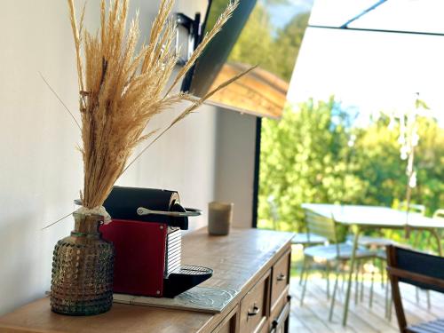 a table with a vase with a book on it at Maisonette Sainte Victoire in Fuveau