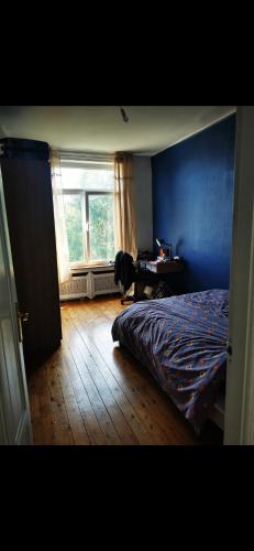 a bedroom with a bed and a desk and a window at Grande maison tout confort, billard et spa -en saison in Lys-lez Lannoy