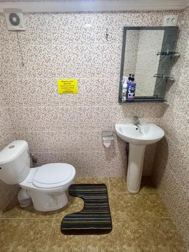 a bathroom with a toilet and a sink at Гостевой дом Сафар in Kapchagay