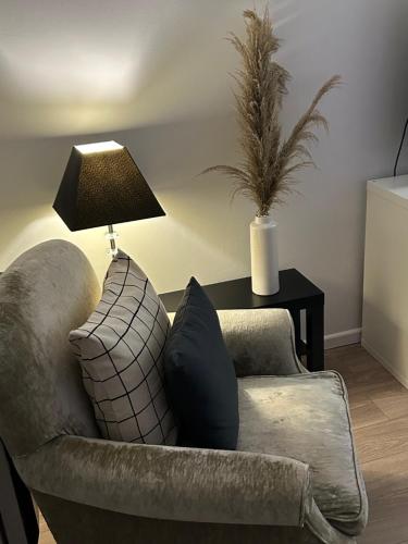 a living room with a couch and a table with a lamp at Lakeside View, Perton Village in Wolverhampton