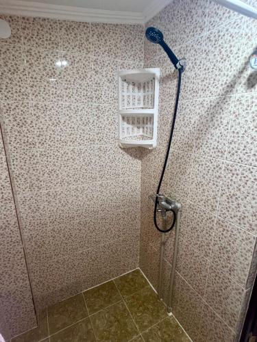 a bathroom with a shower with a basket on the wall at Гостевой дом Сафар in Kapchagay