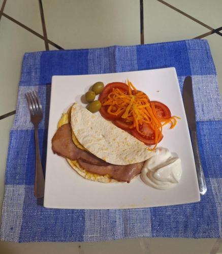 a plate of food with a breakfast sandwich on a table at Hotel Skib in Tbilisi City