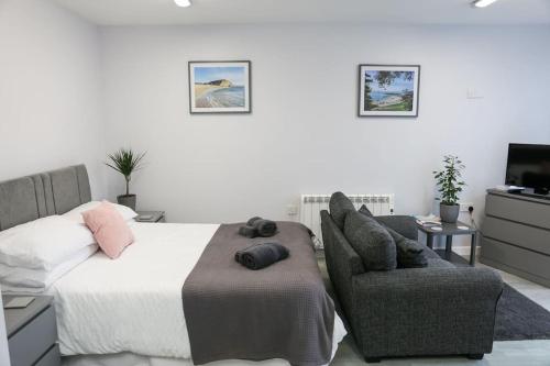 a bedroom with a bed and a chair at Howard Road Home from Home in Bridport