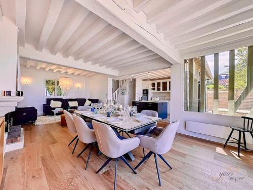 une salle à manger avec une table et des chaises blanches dans l'établissement Horizon 85 YourHostHelper, à Trouville-sur-Mer
