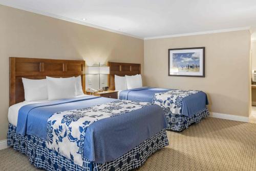 a hotel room with two beds with blue and white sheets at Juniper Hill Inn in Ogunquit