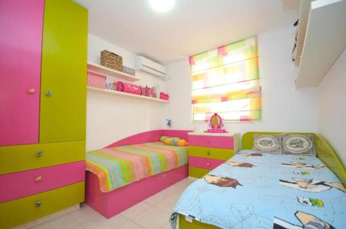 a childs bedroom with colorful cabinets and a bed at Petrovac Bay Apartments in Petrovac na Moru