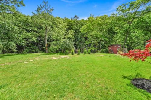 a large grassy yard with a red shed in the background at Charming Hammock by the River in Cressona