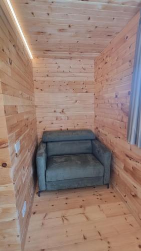 a sauna with a green couch in a wooden wall at Villa Miryam in Ponte di Legno