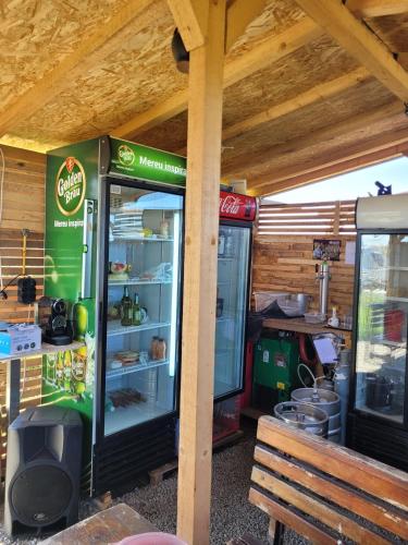 a green refrigerator with food inside of it next to a bench at Makeeda Camping in Vama Veche