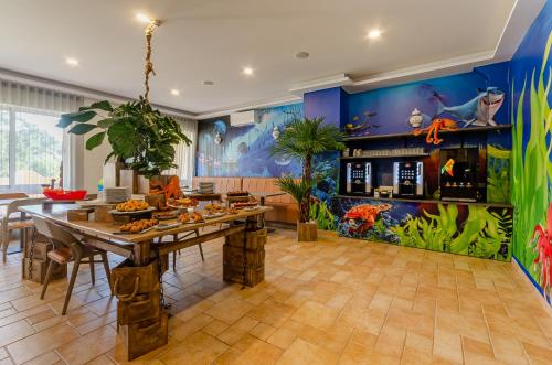 uma sala de jantar com uma mesa grande e um aquário em TURIM Estrela do Vau Hotel em Portimão