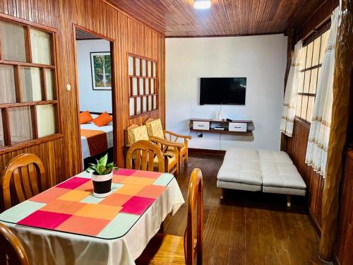 a living room with a table and a tv at CHALET TARAPOTO in Tarapoto