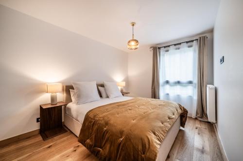 une chambre blanche avec un lit et une fenêtre dans l'établissement Apartment Dolmen Les Gets - by EMERALD STAY, aux Gets