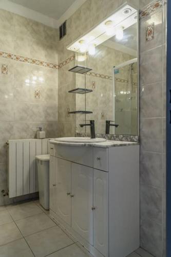 une salle de bain avec un lavabo et un miroir dans l'établissement Vacances entre mer et montagne, à Alès