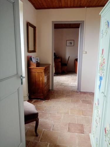 Cette chambre dispose d'un couloir avec une table et une chaise. dans l'établissement Le Clos Saint Georges, à Donnazac