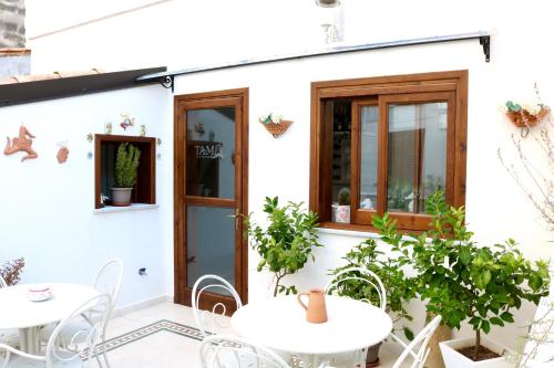 a patio with tables and chairs and a white house at TAM Vacanze B&B in Cinisi