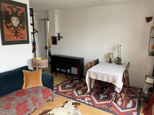 un salon avec une table et un canapé dans l'établissement Deux pièces lumineux calme, vue sur le ciel !, à Paris