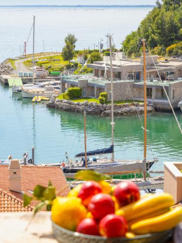a bowl of fruit sitting on a table near a marina at Portopiccolo Apartments in Sistiana