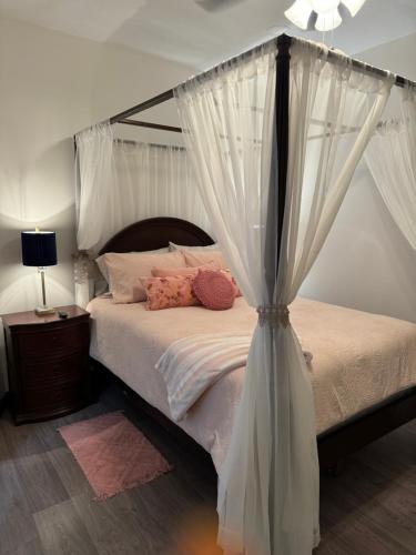a bedroom with a canopy bed with white curtains at Sugar on The Sugar River in Albany