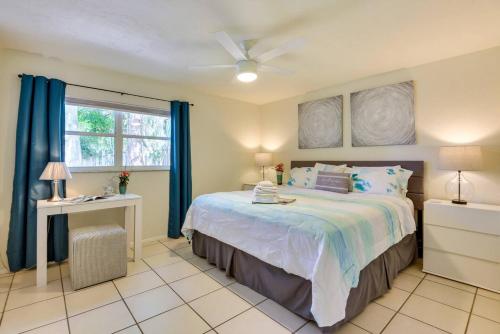 a bedroom with a bed with blue curtains and a window at Coconut Cove Mid-long term stays available Walk to Downtown Trolly to BEACHES in Sarasota