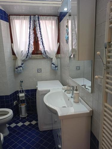 a bathroom with a sink and a toilet and a mirror at Villa Ontanelli - 500mt dal mare in Marciana Marina