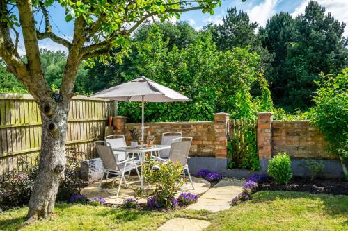 a table and chairs with an umbrella in a garden at The Birdie in York