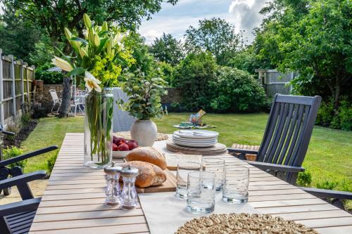 a wooden table with plates of food and flowers on it at The Birdie in York