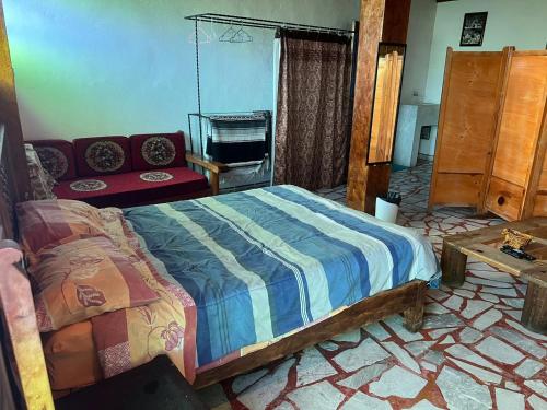 a bedroom with a bed and a couch in it at Luna in Taxco de Alarcón