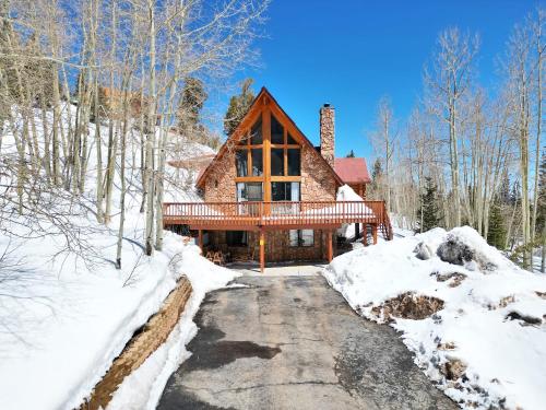 a log home in the snow with a driveway at Arcade Games Brian Head Resort Newly Renovated in Brian Head