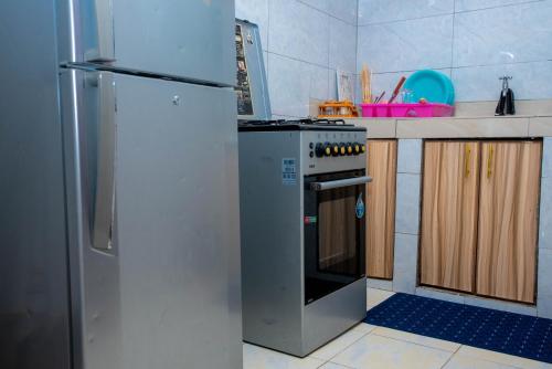 a kitchen with a refrigerator and a stove at Icydunex in Ruiru