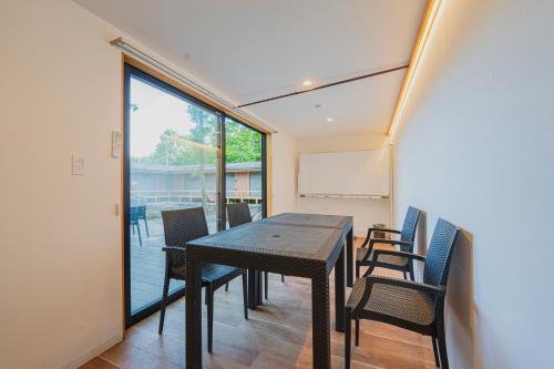 a dining room with a table and chairs at 森deワーケなすっぽ 木の温もりとホテルライクな佇まい 森のバレルサウナ in Nasu