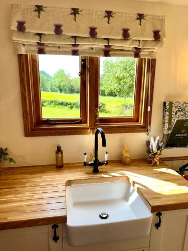 a kitchen counter with a sink and a window at Lintmill Lodges - Thistle Shepherds Hut in Sorn