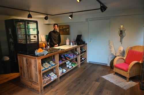a man standing behind a counter in a room at Tiny House Nature 17 - Green Tiny Village Harz in Osterode