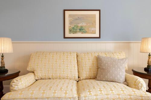 un divano in una stanza con due lampade di Kouneni Apartments a Mykonos Città