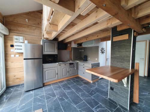 Il comprend une cuisine équipée d'un réfrigérateur et d'une table en bois. dans l'établissement La Casetta, à Thaon-les-Vosges