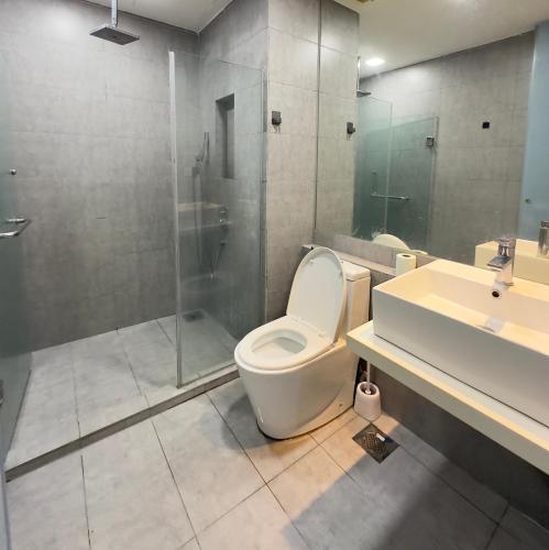 a bathroom with a toilet and a shower and a sink at Sunset View Condo Cyberjaya in Cyberjaya