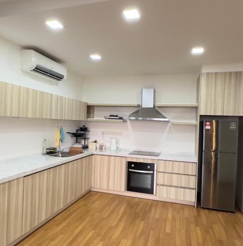 a kitchen with stainless steel appliances and wooden cabinets at Sunset View Condo Cyberjaya in Cyberjaya