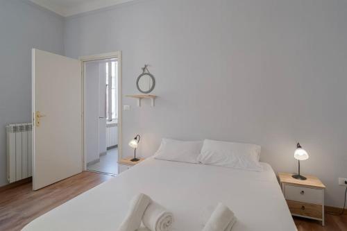 una camera da letto bianca con un letto grande e due lampade di Bilocale Mazzini a Ventimiglia