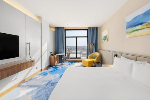 a hotel room with a bed and a flat screen tv at Holiday Inn Riyadh The Business District by IHG in Riyadh