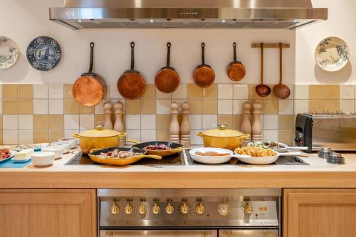 a kitchen with many pots and pans on a counter at Villa Camille Hotel & Spa in Banyuls-sur-Mer